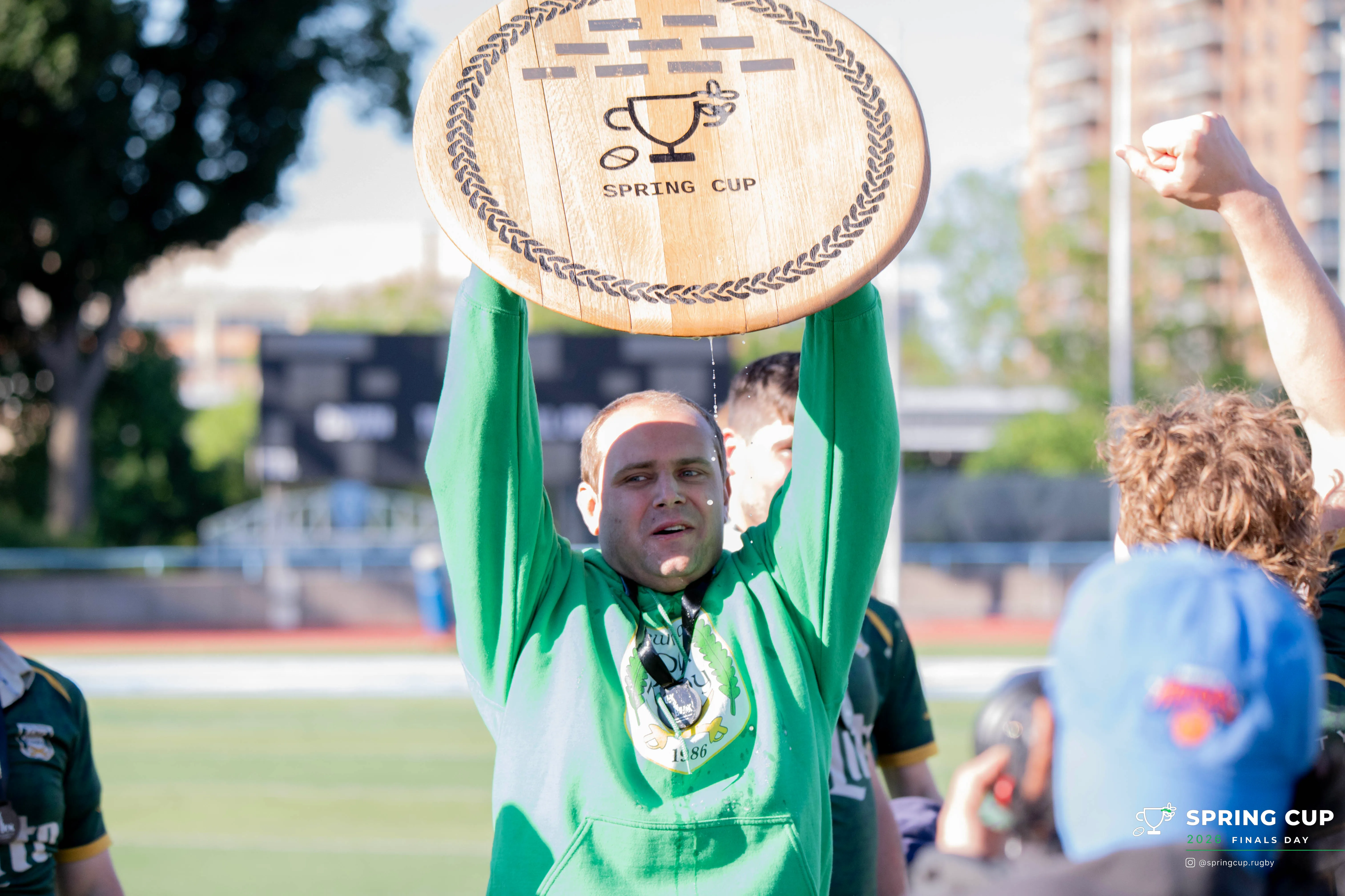 A champion lifts the hand-crafted wooden Spring Cup overhead